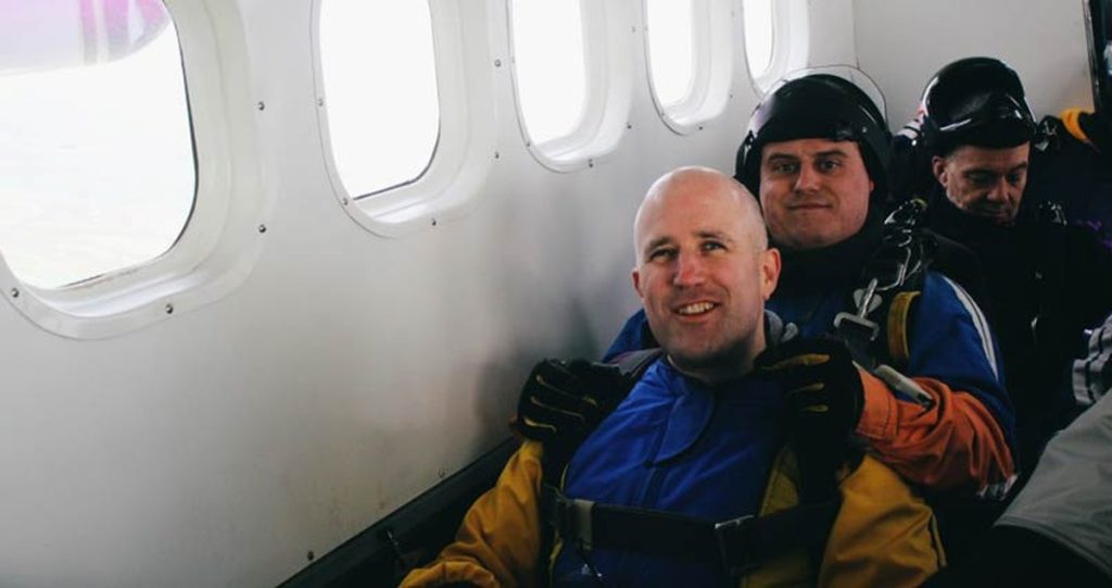 Neil Martin and his tandem instructor sitting on the floor of the plane before the jump