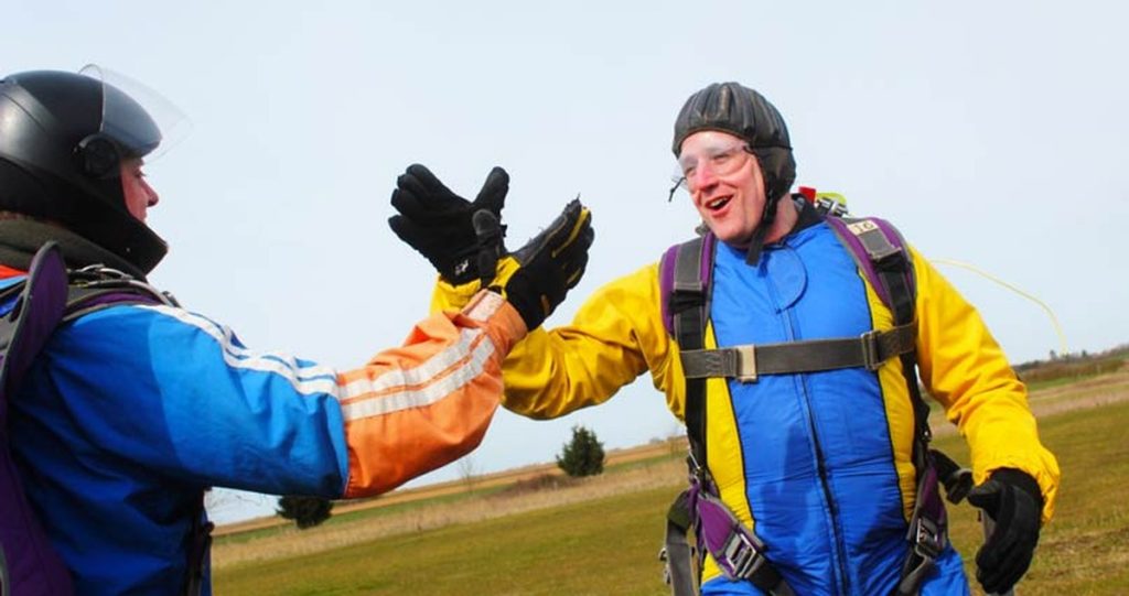 Neil Martin high-fiving his instructor after landing