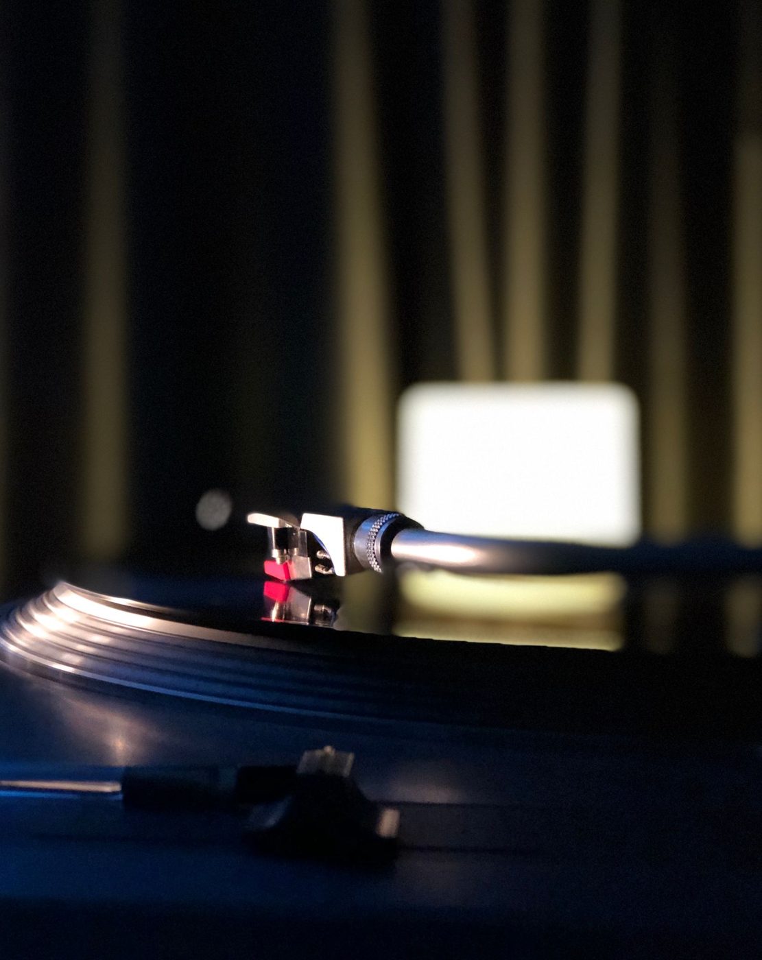 Turntable with a vinyl record in low blue light