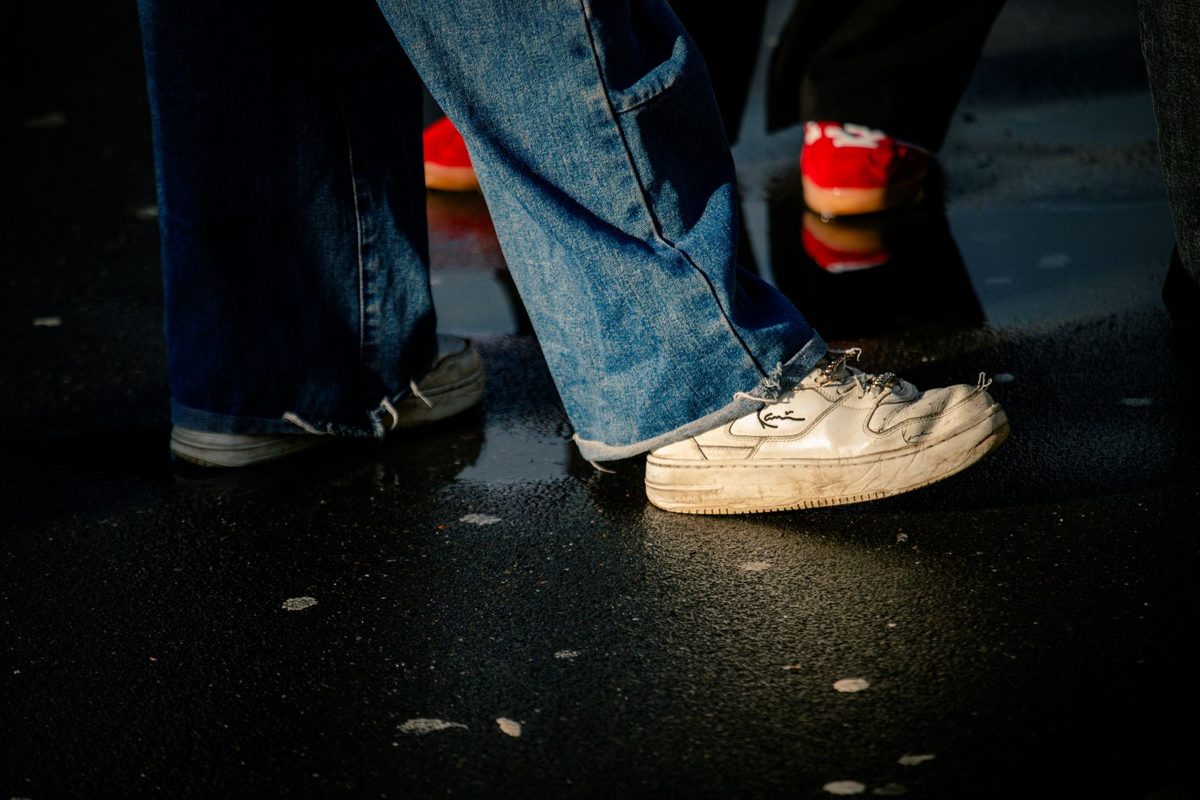 White trainers on a wet city street at night